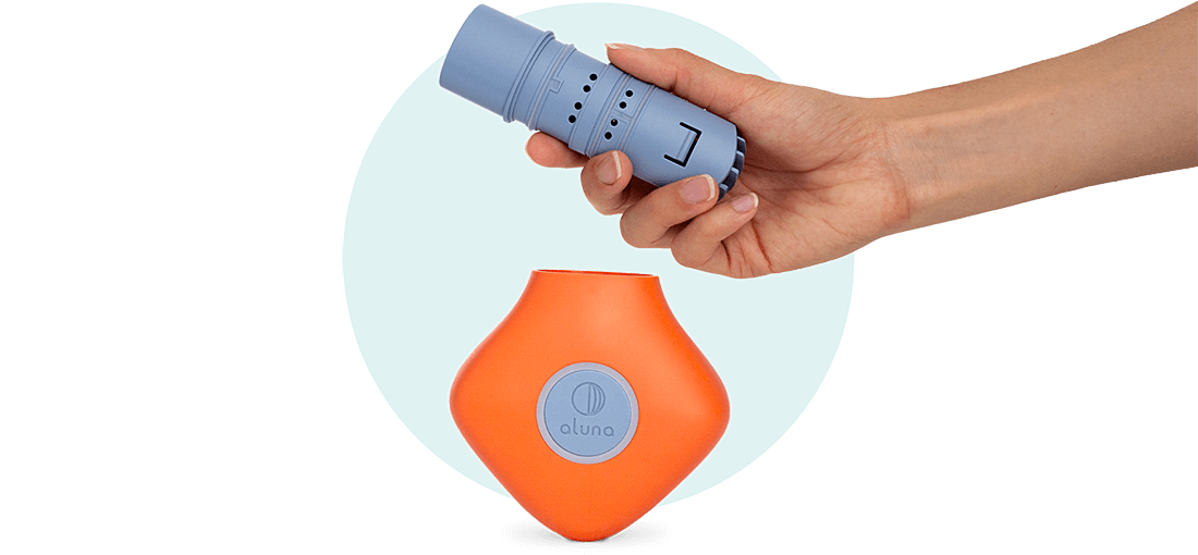 A hand holding the device's removable mouthpiece.